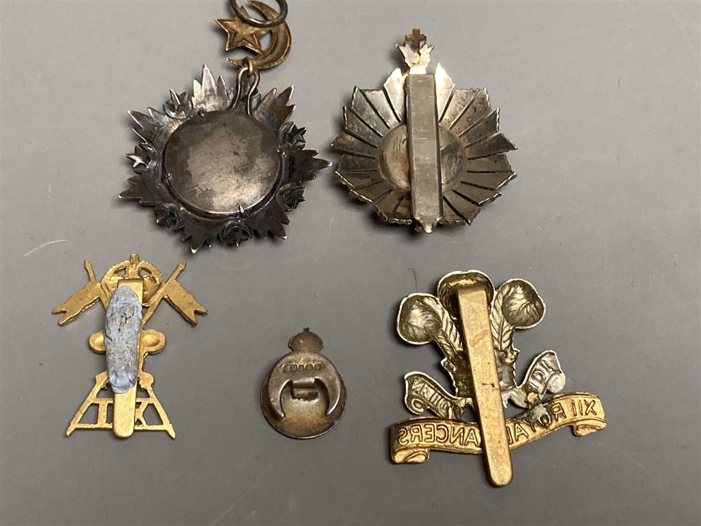 A Turkish Ottoman Order Medjidie Knights Star, another star and three English regimental badges